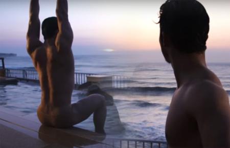 Two young men watching a sunset from beside a pool