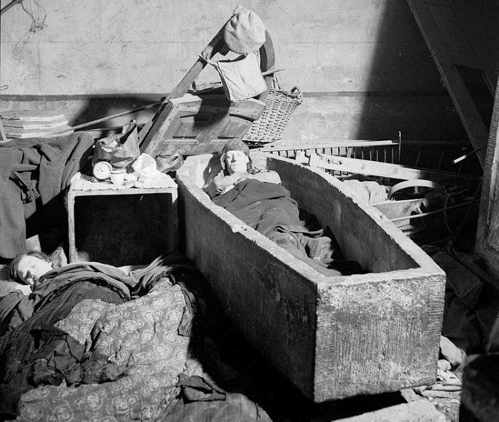 A man lying in an open stone coffin